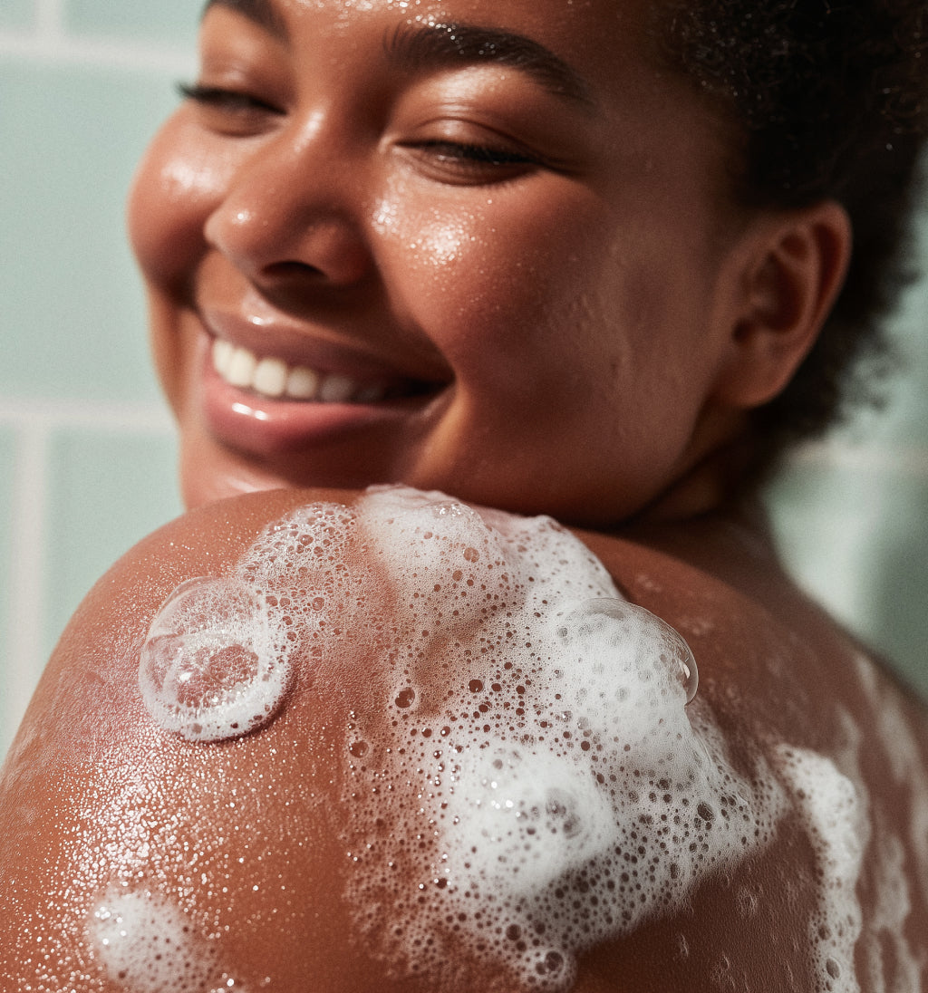 Woman with soap suds on her shoulder in a bathroom setting